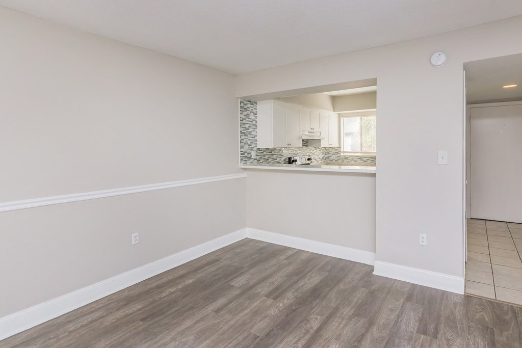 the living room and kitchen of an empty apartment