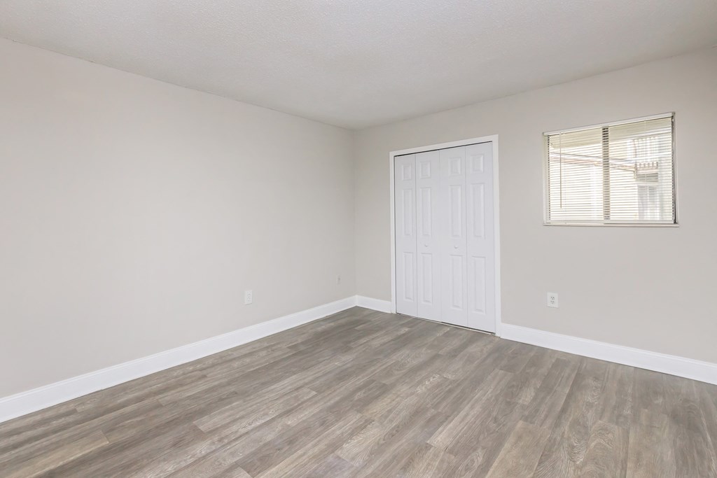 an empty living room with wood floors and a white door