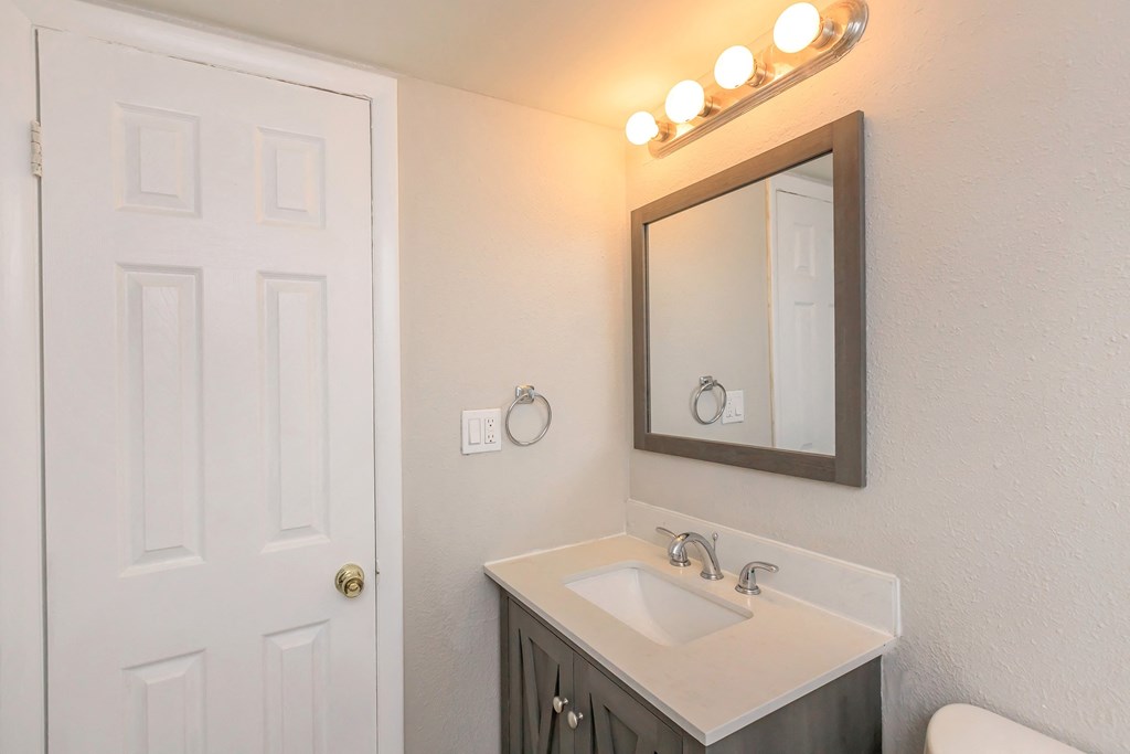 a white bathroom with two sinks and a mirror