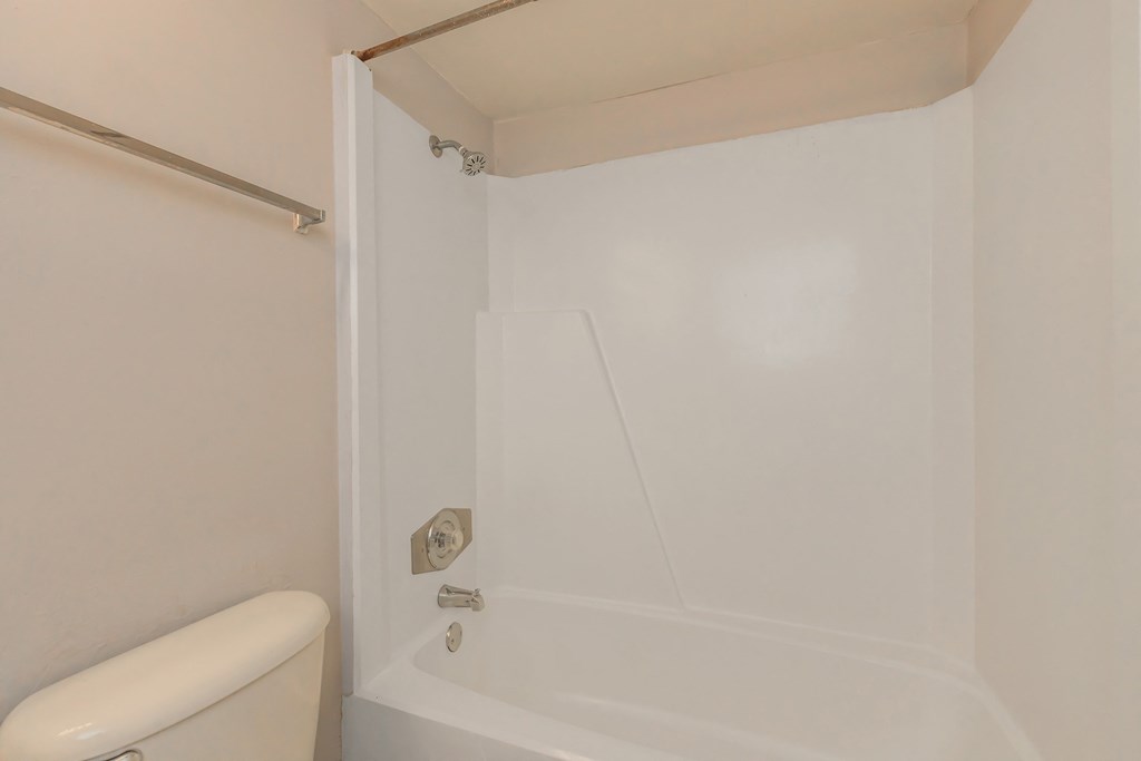a white bathroom with a tub and a toilet