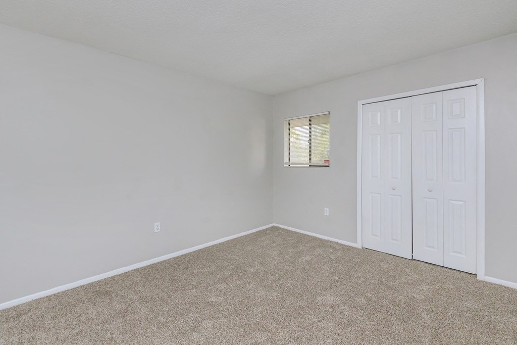 an empty bedroom with white walls and a white door