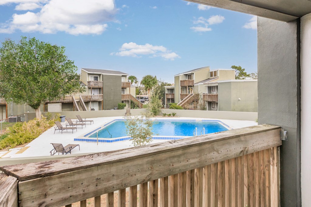 a view of the pool from the balcony of an apartment building