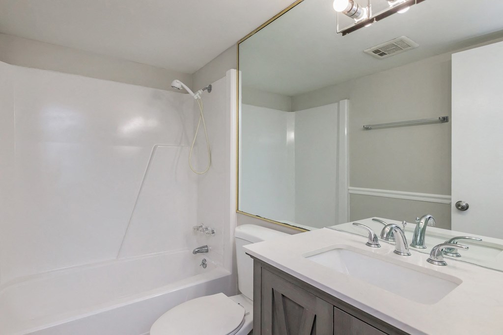 a bathroom with a sink toilet and shower and a mirror