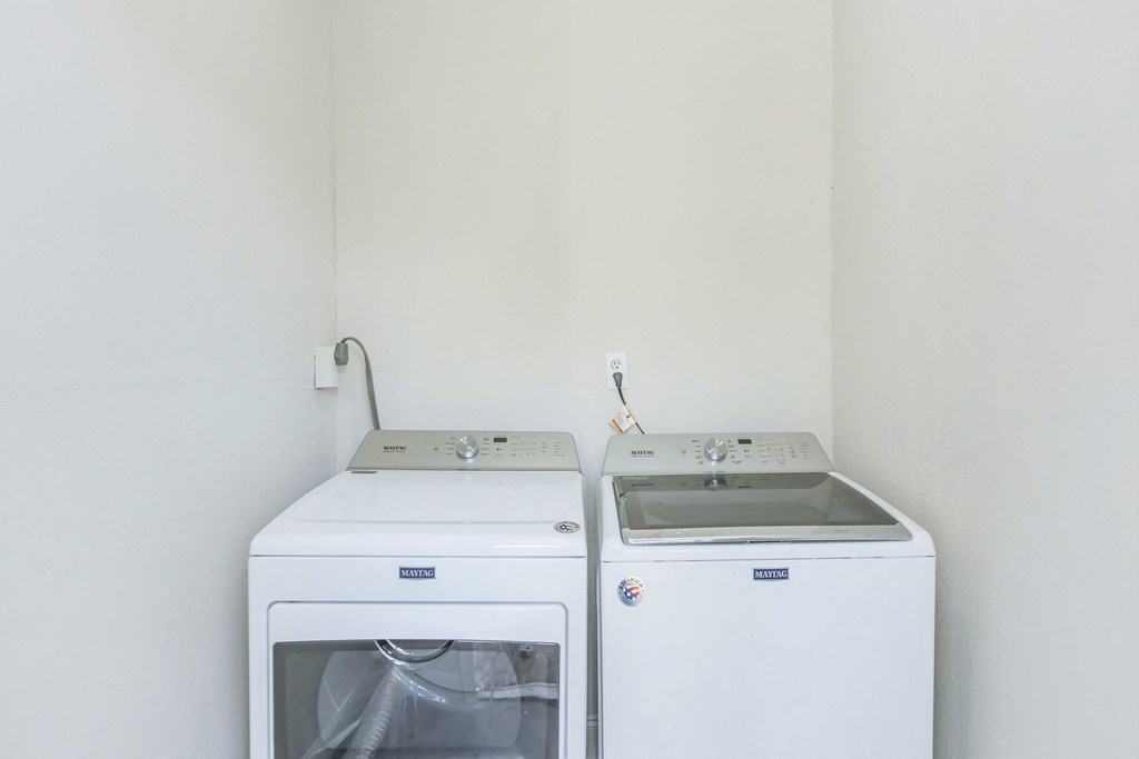 an empty kitchen with a stove and a washer and dryer
