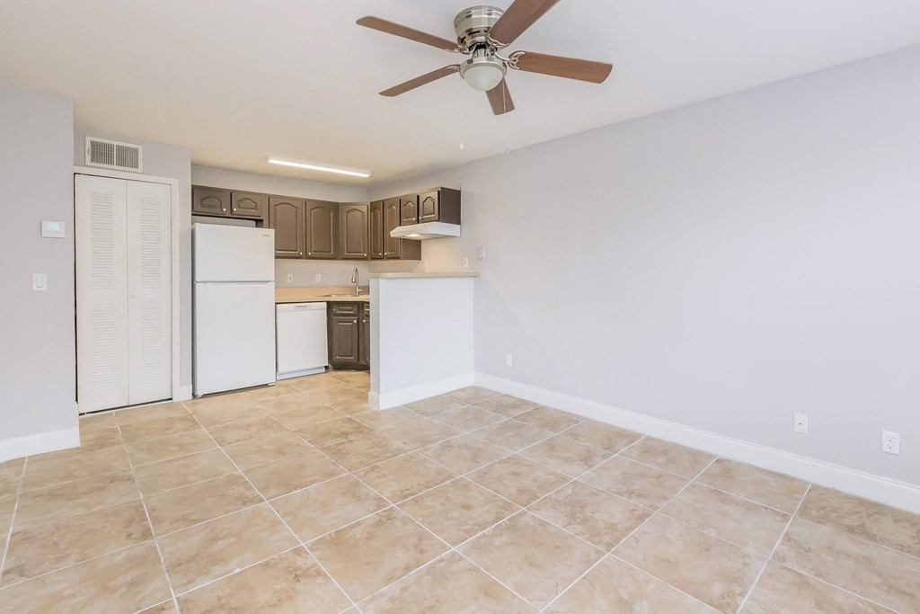 an empty kitchen and living room with a ceiling fan