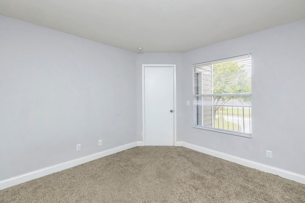 an empty room with carpet and a window