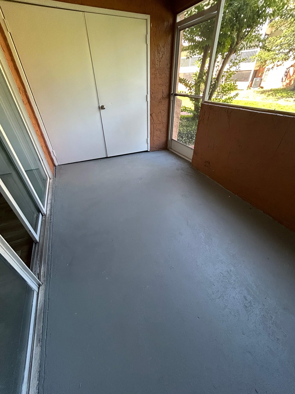 A room with a grey floor and a white door.