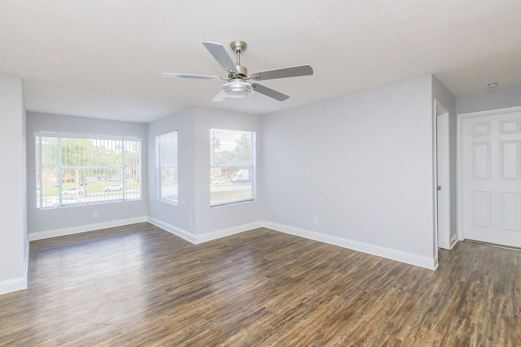 an empty room with striped walls and a ceiling fan
