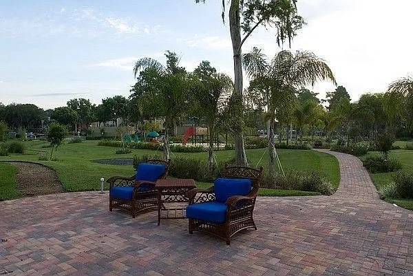 Two chairs are on a brick patio.