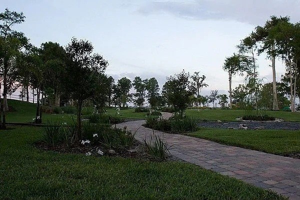 A pathway leads through a grassy area with trees on either side.
