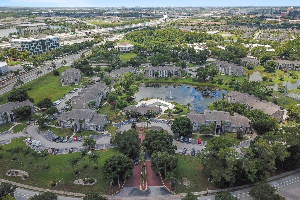 an aerial view of a city with a pond and buildings
