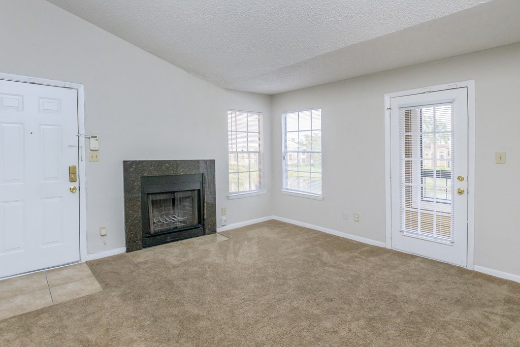an empty living room with a fireplace and a door