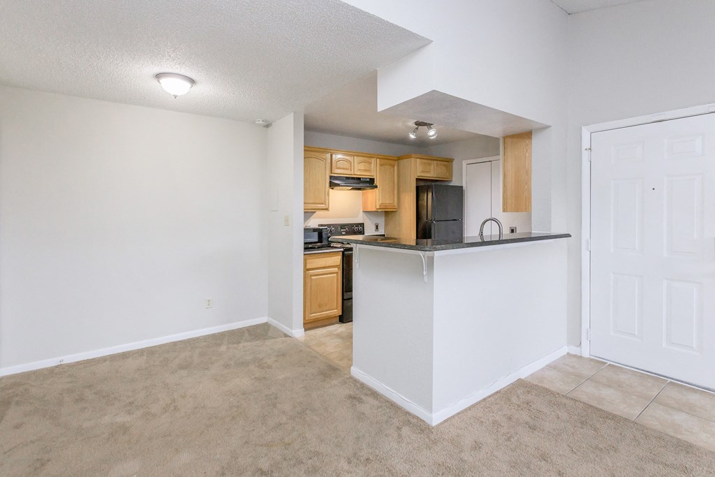 an empty living room and kitchen with a counter top and