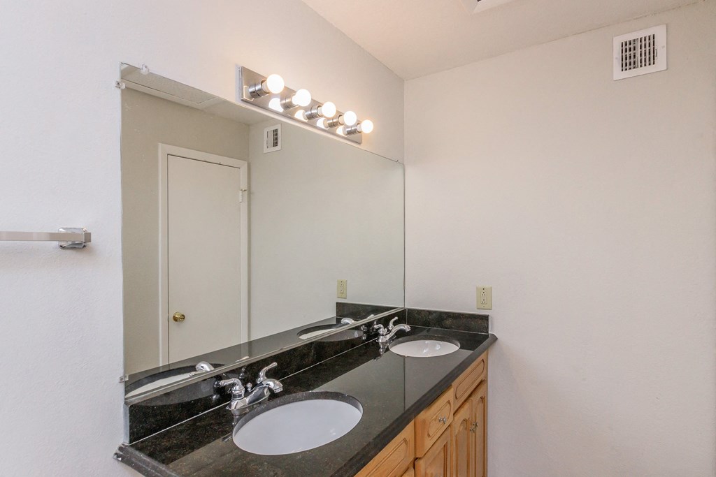 a bathroom with two sinks and a large mirror