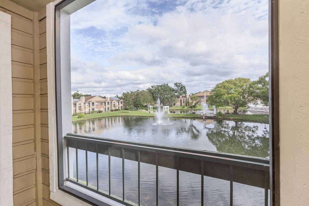 a view of a pond with a fountain from a balcony