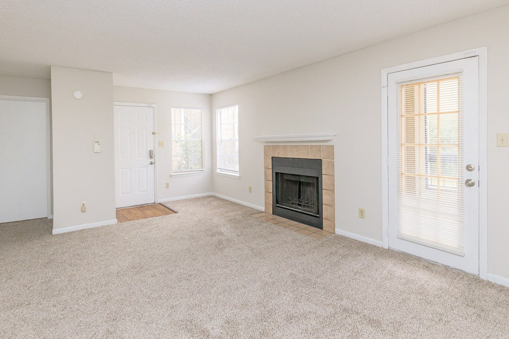 an empty living room with a fireplace and a door