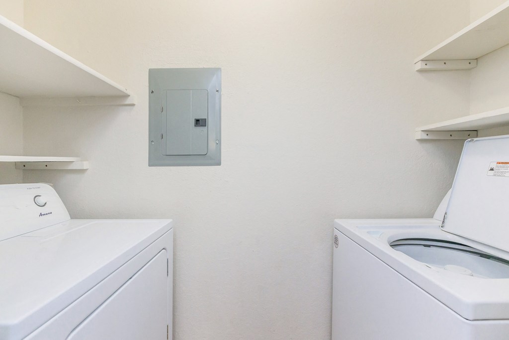 an empty laundry room with a washer and dryer and a dryer door