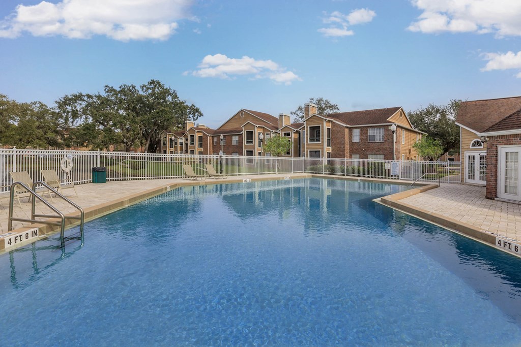a large swimming pool with houses in the background