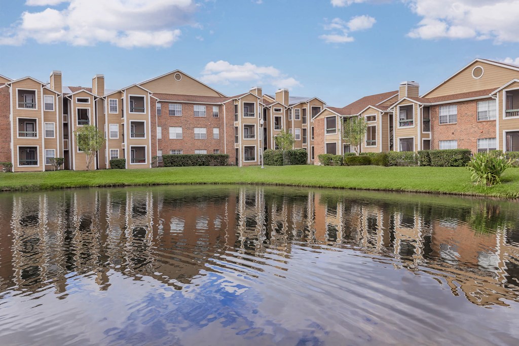 an apartment building is reflected in a pond