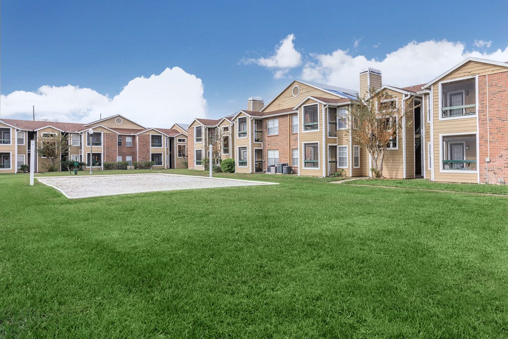 a large green lawn in front of an apartment building
