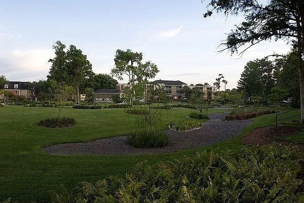 A park with a gravel path and green grass.