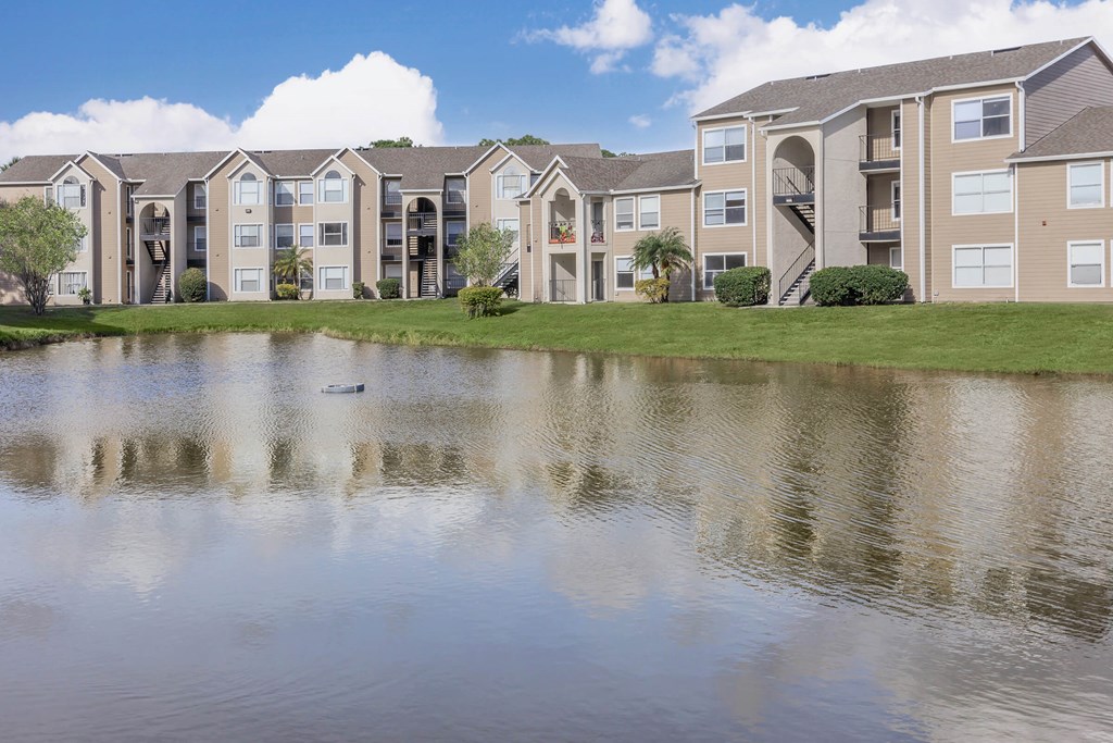 an apartment building overlooking a pond with a duck in it
