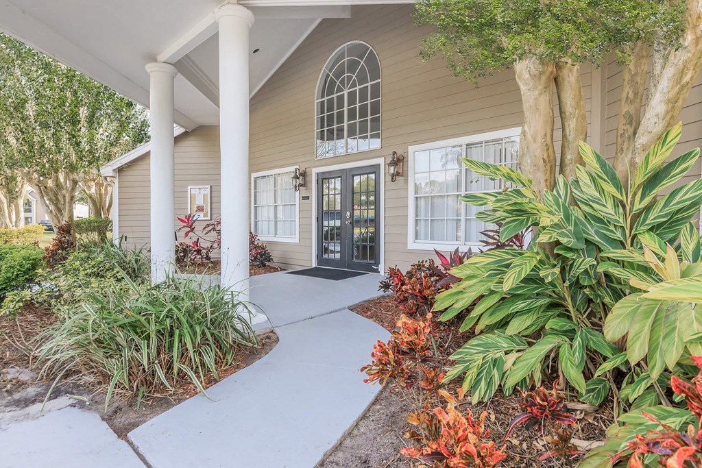 the front entrance of a house with a porch and plants