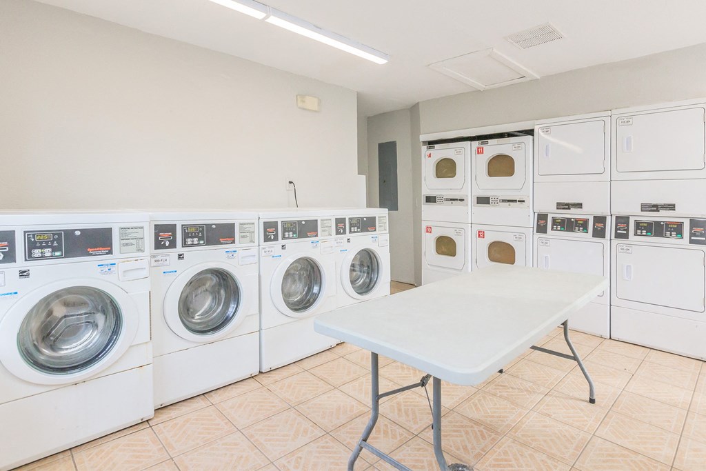 a washer and dryer room with a table and washing machines