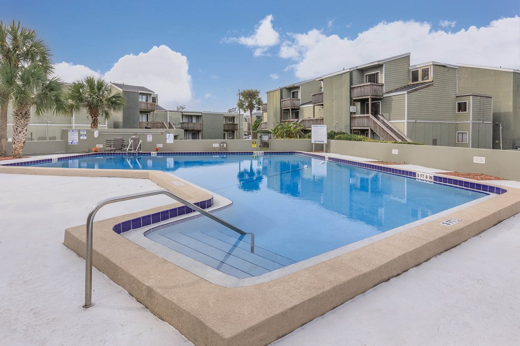 a large swimming pool in front of apartment buildings