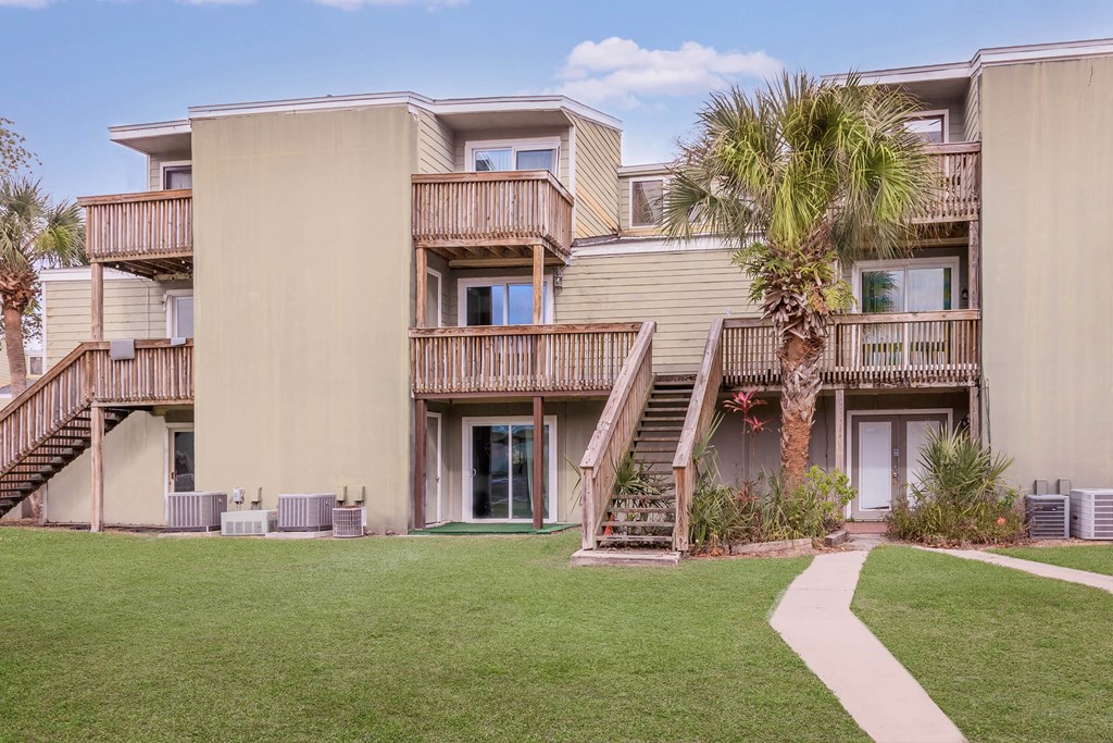 a building with stairs and a palm tree in front of it