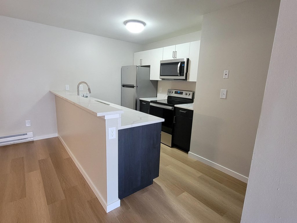 a kitchen with an island and a stainless steel refrigerator