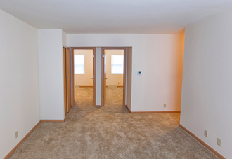 an empty room with three doors and a carpeted floor