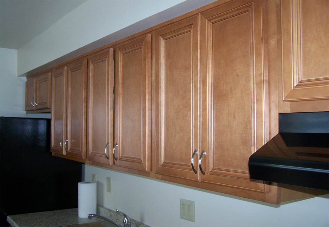 a kitchen with wooden cabinets and a black counter top