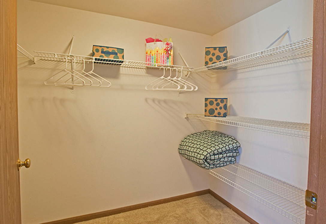 the spacious closet has plenty of shelves and hooks for clothes