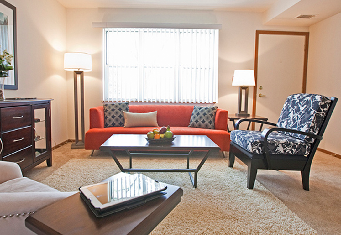 a living room with a orange couch and a coffee table