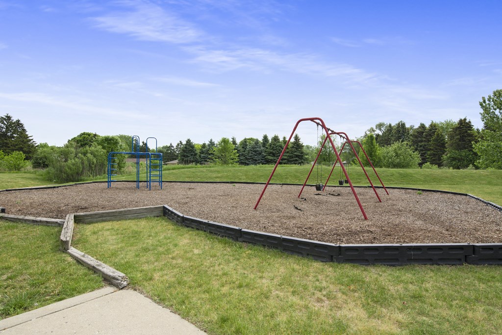 a playground with a swing set in a park