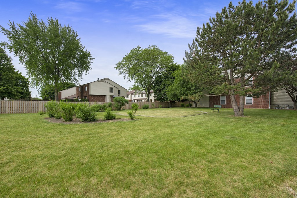 the backyard of a house with a yard and trees