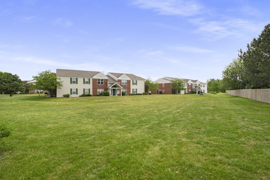 the view of a large lawn in front of a row of houses