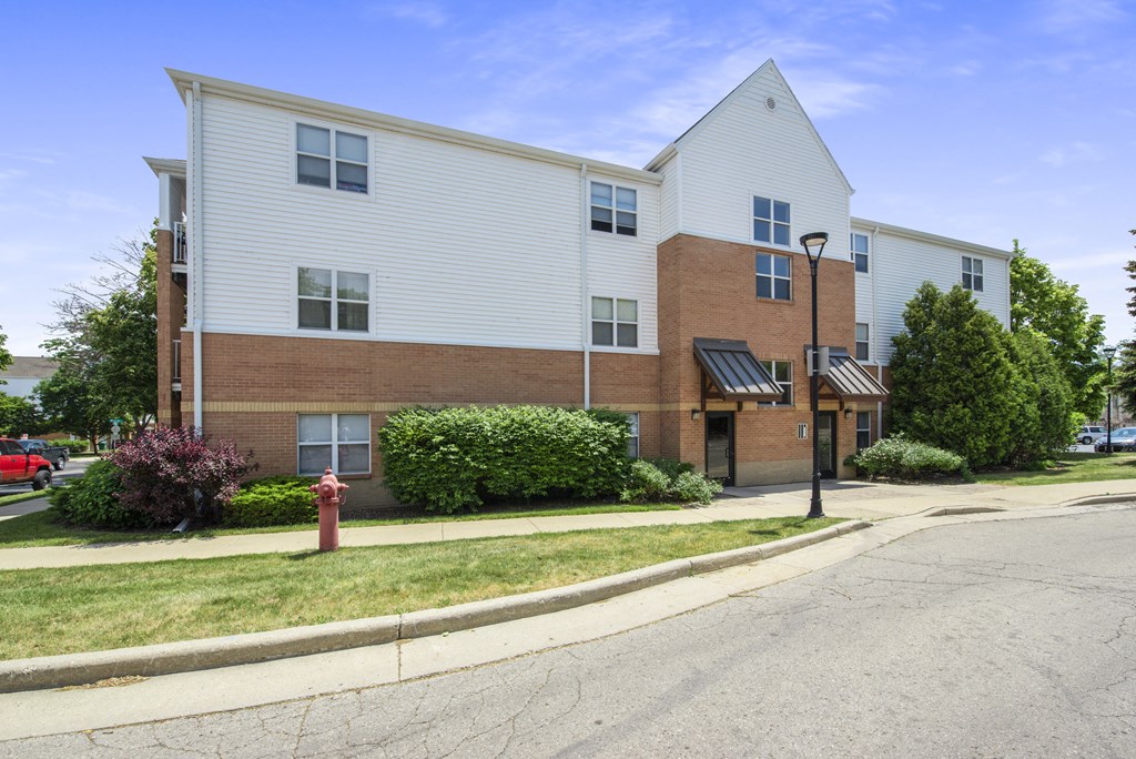 an apartment building on the corner of a street with a fire hydrant