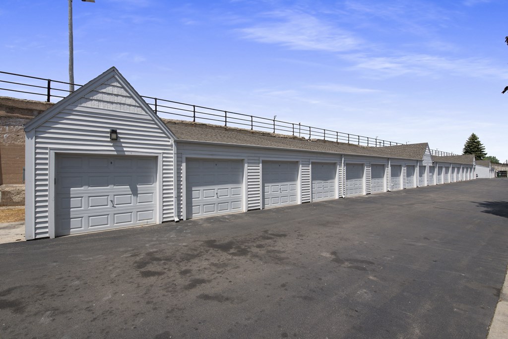 a row of garages with white doors and a roof