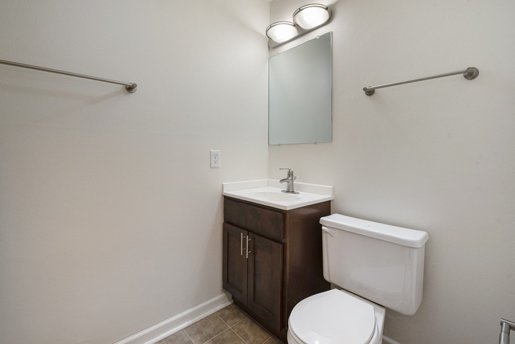 an empty bathroom with a toilet sink and mirror