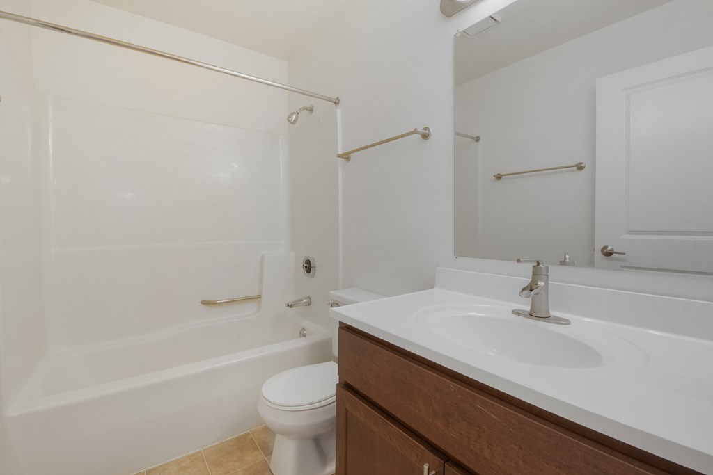 an empty bathroom with a sink toilet and shower