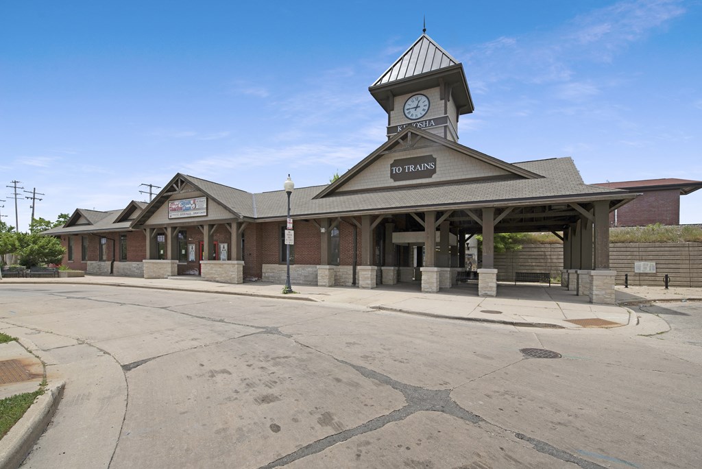 an empty street in front of a building with a clock tower