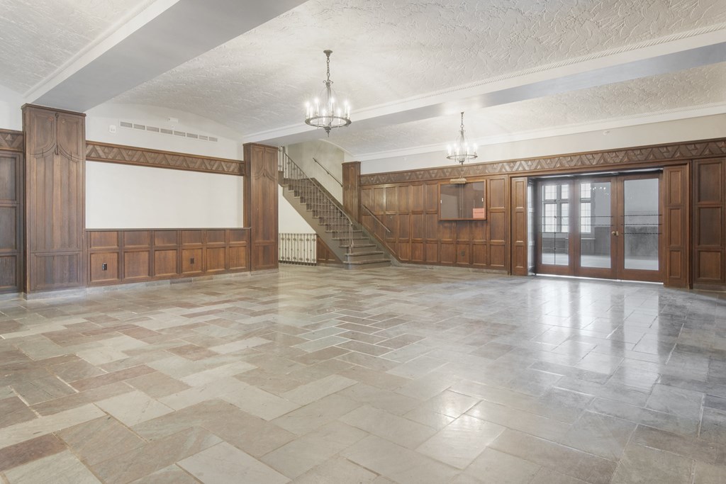 an empty room with wood paneling and a staircase in the middle
