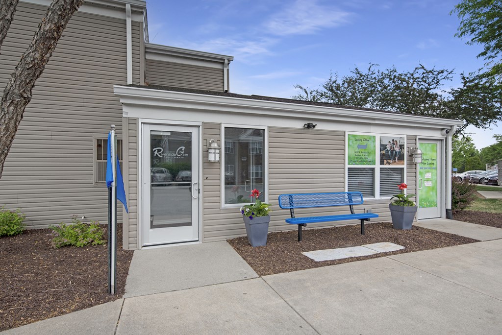 a bench in front of a building with a door and a window