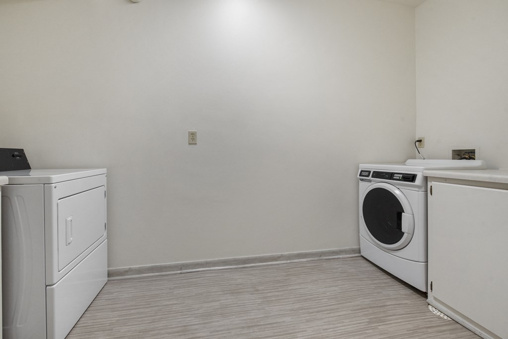 an empty room with a washing machine and a washer and dryer in it