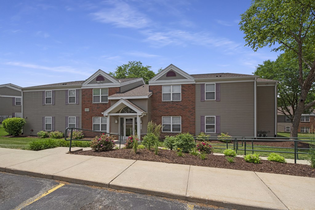 an apartment building with a sidewalk in front of it