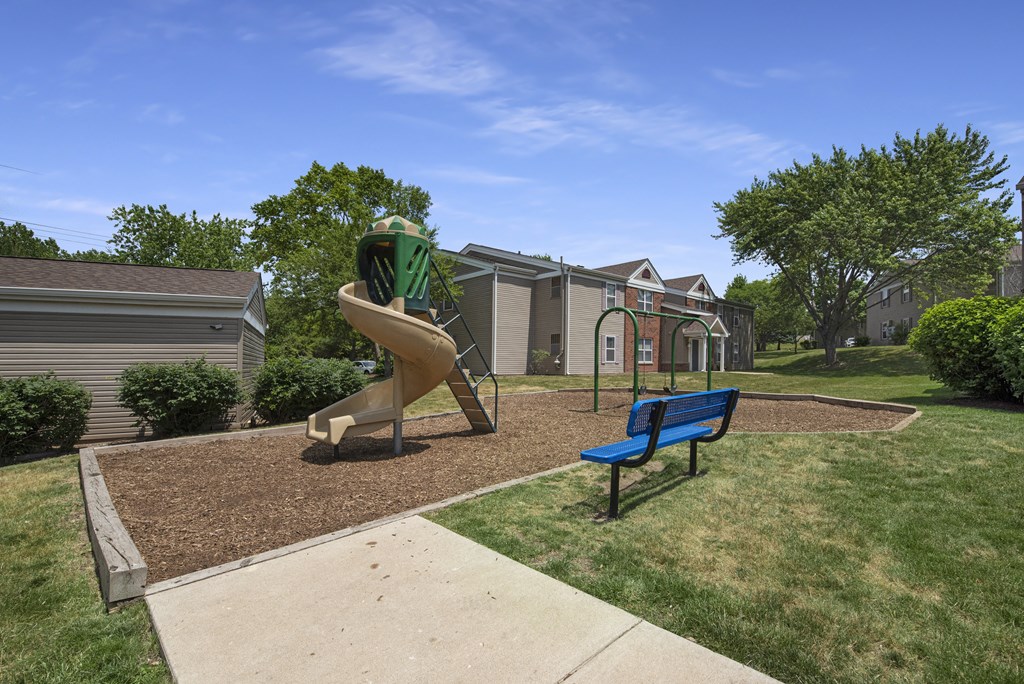 the preserve at ballantyne commons playground with play equipment and a blue bench