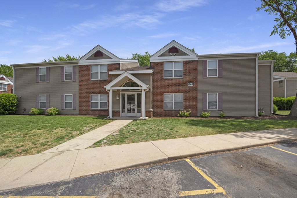 a brick house with a sidewalk in front of it