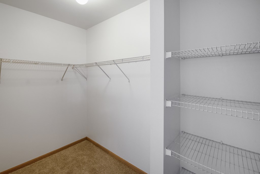 an empty closet with empty shelves in a white room